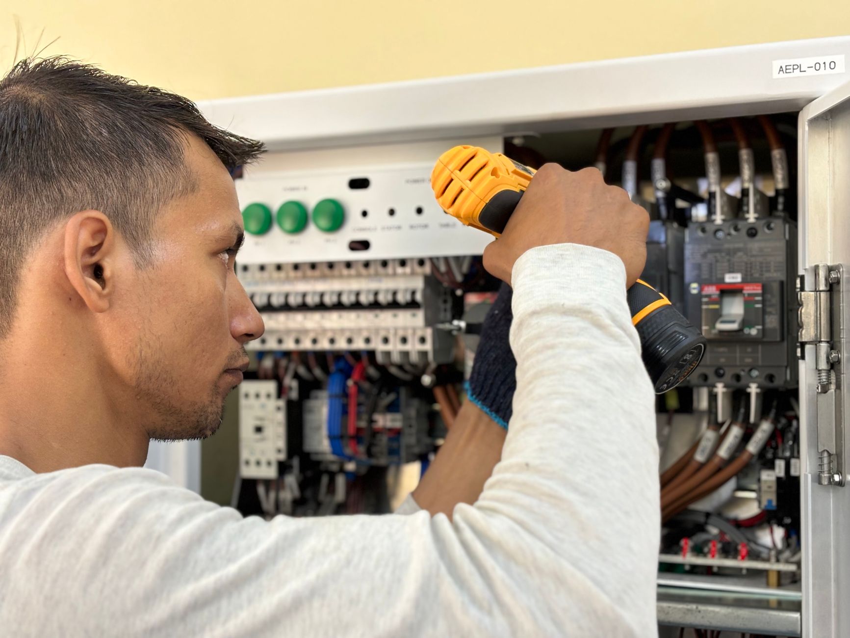 An electrician inspecting a home electrical panel before an EV charger installation