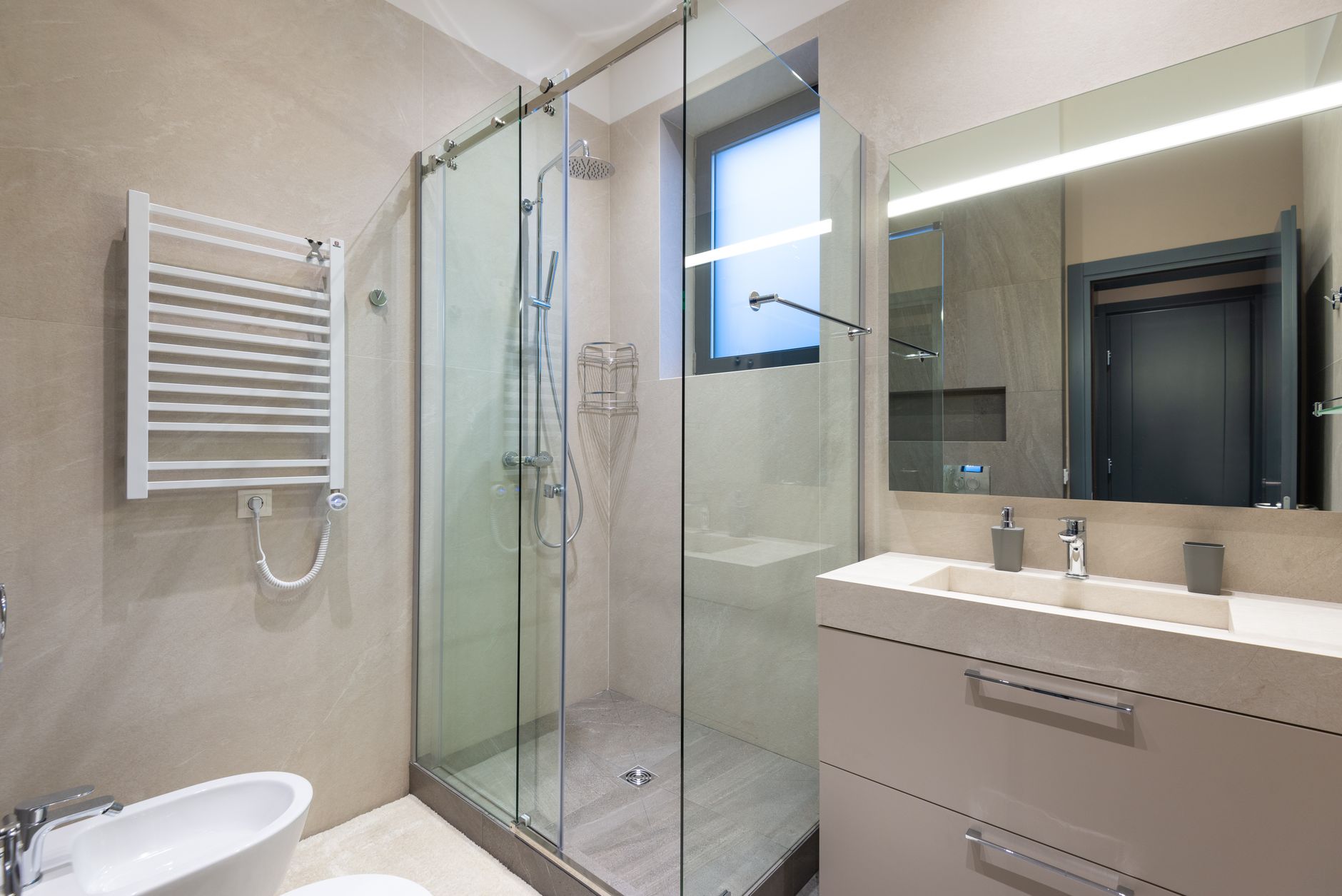 A bright bathroom renovation in progress with modern fixtures and tiling under warm natural light.