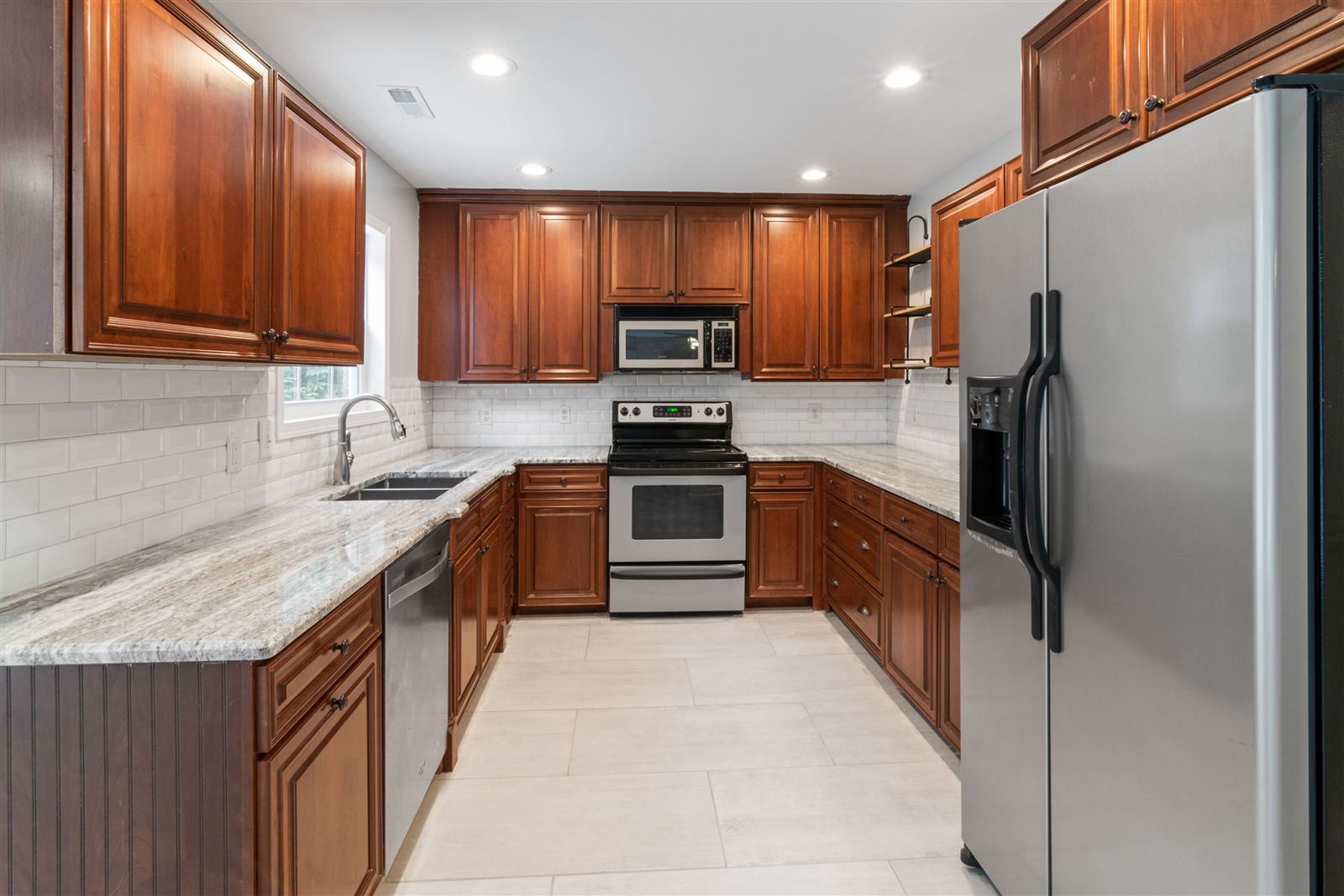 A renovated Vancouver kitchen with wood cabinets, granite countertops, and new stainless steel appliances