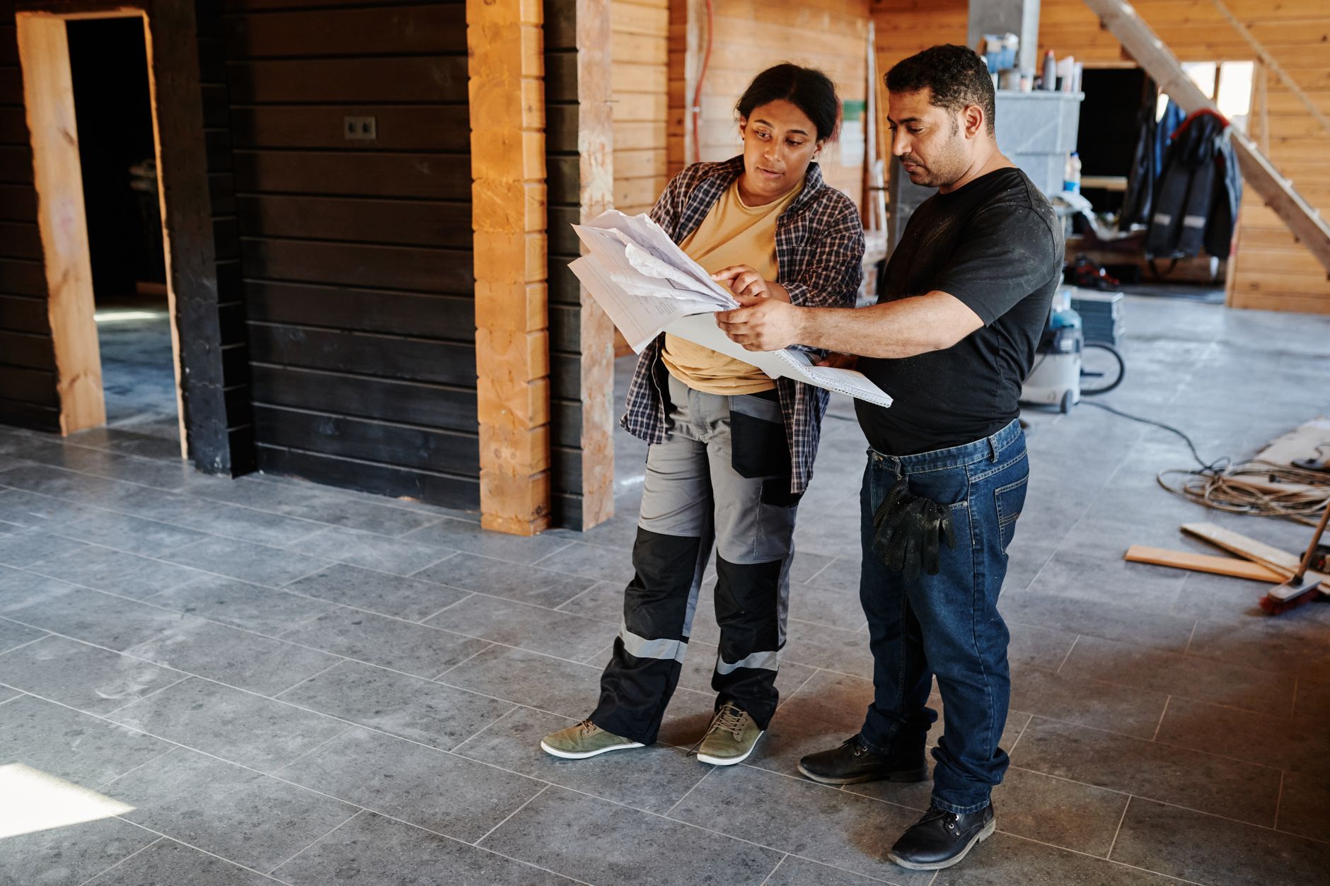 Contractor and client reviewing renovation plans together inside a home under construction