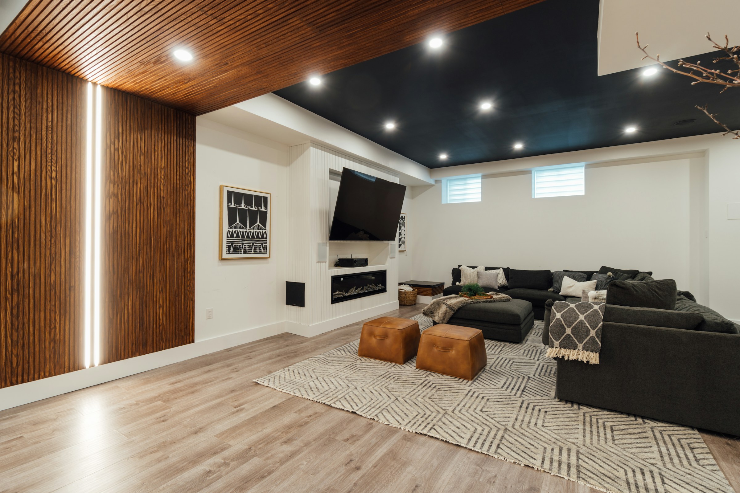 Finished basement rec room with modern flooring and lighting
